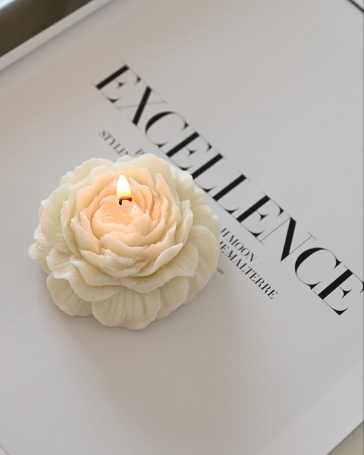 decorative candle set with a flower-shaped candle and an elegant ribbed container with lid, placed on a tray
